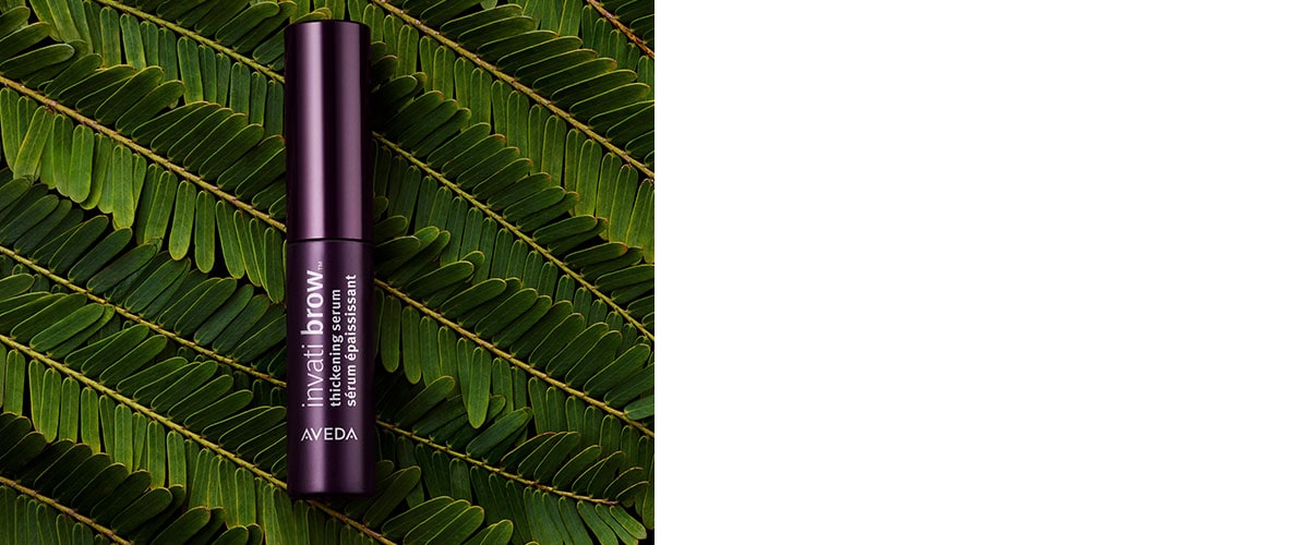 invati brow serum on top of a large green leaf